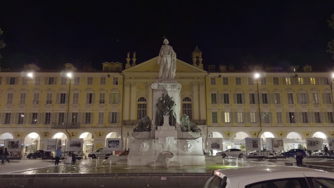 Night view of a historical European square with a monument and fountain