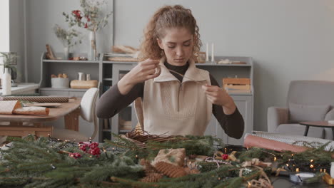 mujer haciendo una corona de navidad