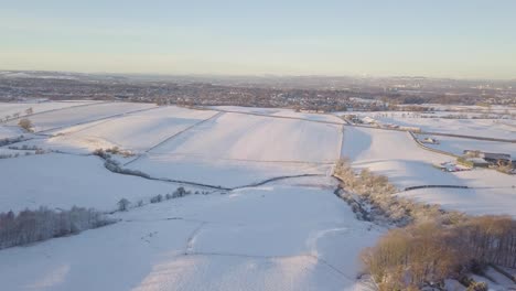 Ländliche-Winterlandschaft-Mit-Einem-Haus-Und-Feldern,-Die-Mit-Weißem-Schnee-Bis-Zum-Horizont-An-Einem-Hellen-Kalten-Tag-In-Schottland-Während-Der-Goldenen-Stunde-Bedeckt-Sind