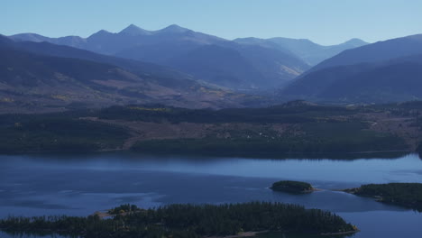 Early-fall-colors-Lake-Dillon-islands-Colorado-aerial-cinematic-drone-morning-view-Frisco-Breckenridge-Silverthorne-Ten-Mile-Range-calm-reflective-water-yellow-Aspen-trees-zoom-pan-up-reveal-movement