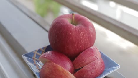 manzana roja fresca cortada en un plato azul