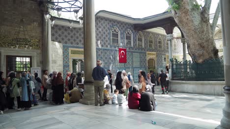 interior of a historical turkish building, likely a mosque, with visitors