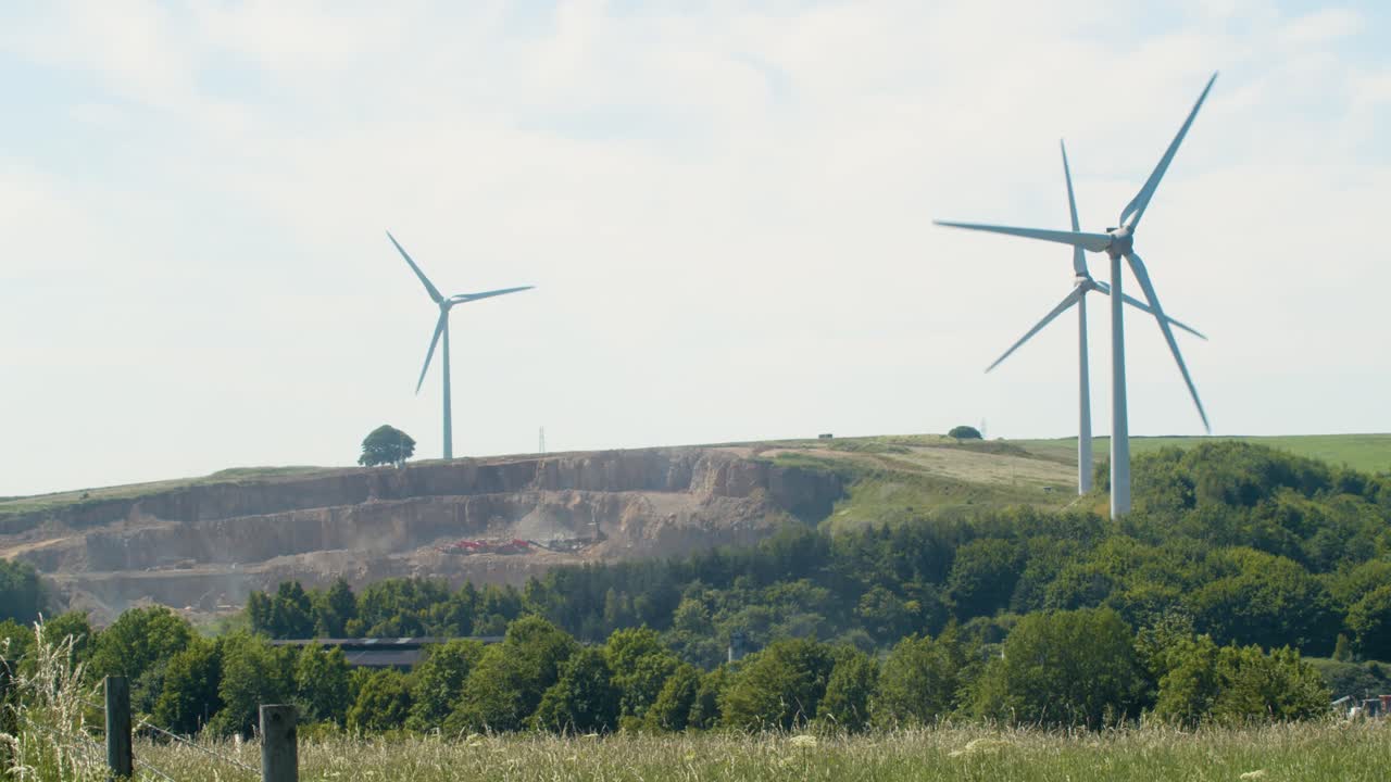 ветряные турбины быстро вращаются в теплый солнечный день в английской сельской местности