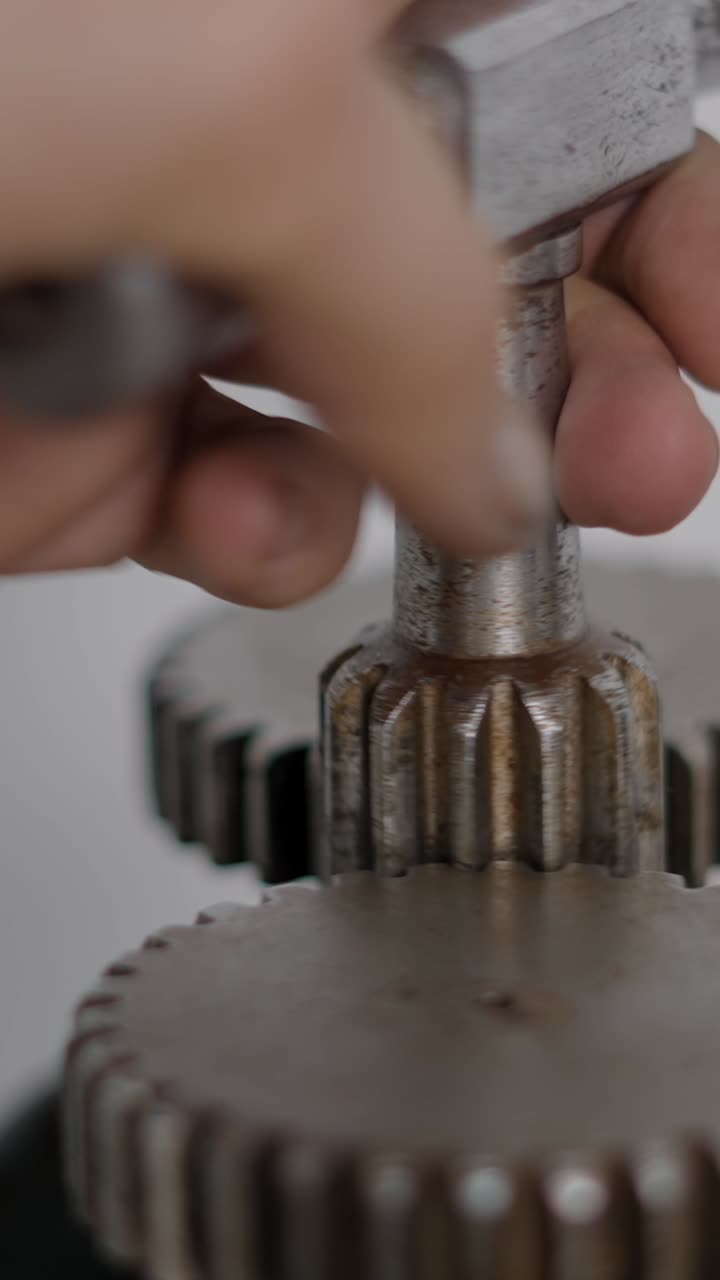 Close-up of a hand operating metal gears