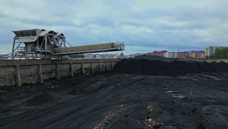 coal power plant's coal storage area is empty as the plant is being shut down, helsinki in the background