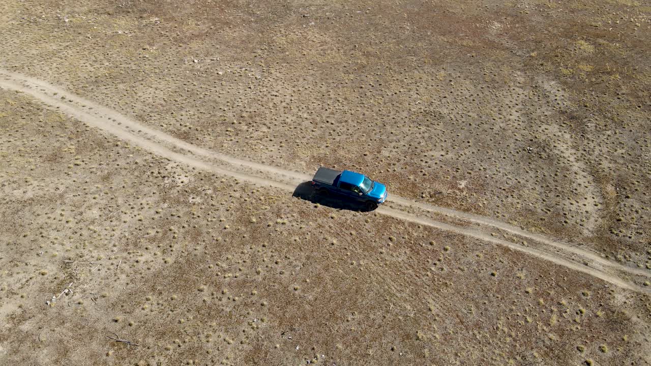 사막에서 4륜 흙길을 따라 운전하는 트럭 - 항공 보기