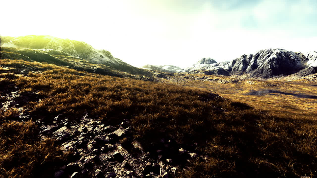 Majestic mountain landscape at golden hour with lush grass and rocky terrain