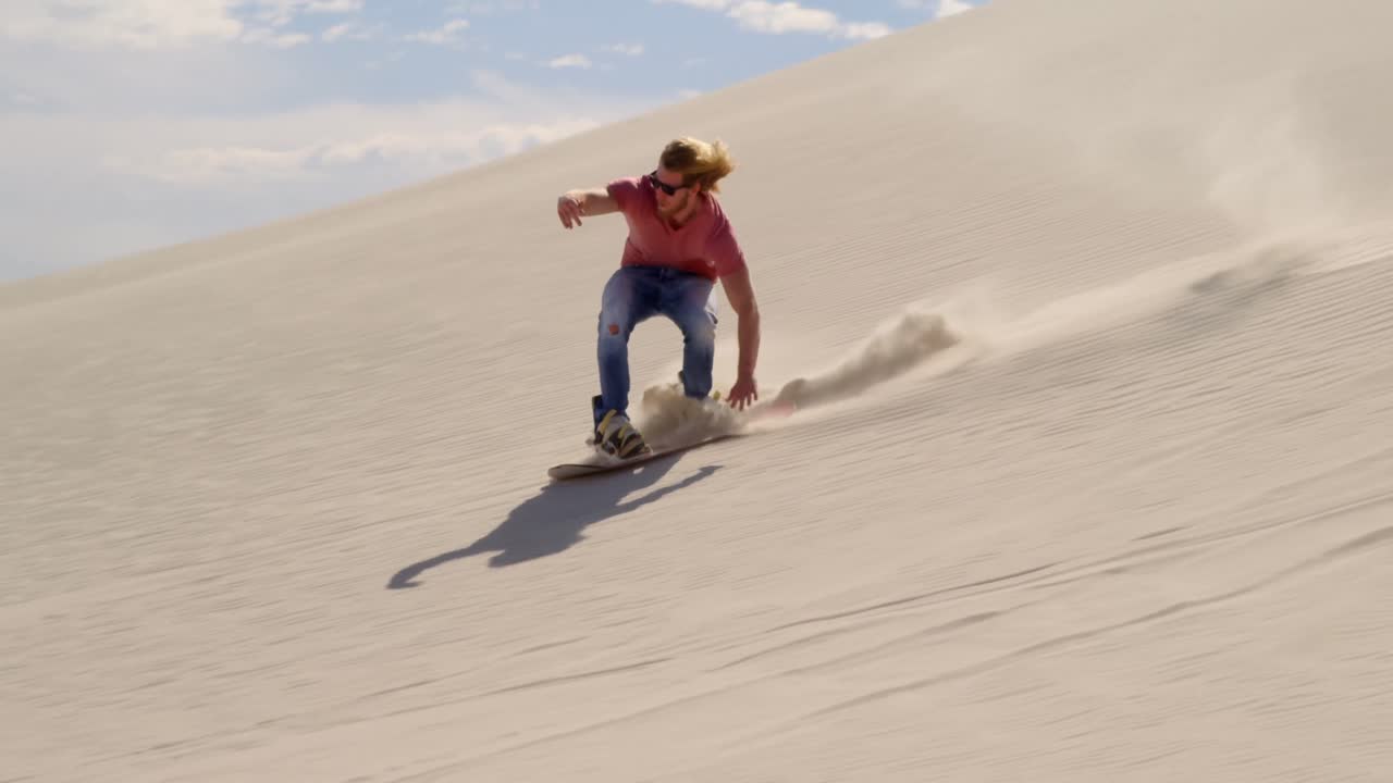 hombre de arena abordando en la pendiente en el desierto 4k
