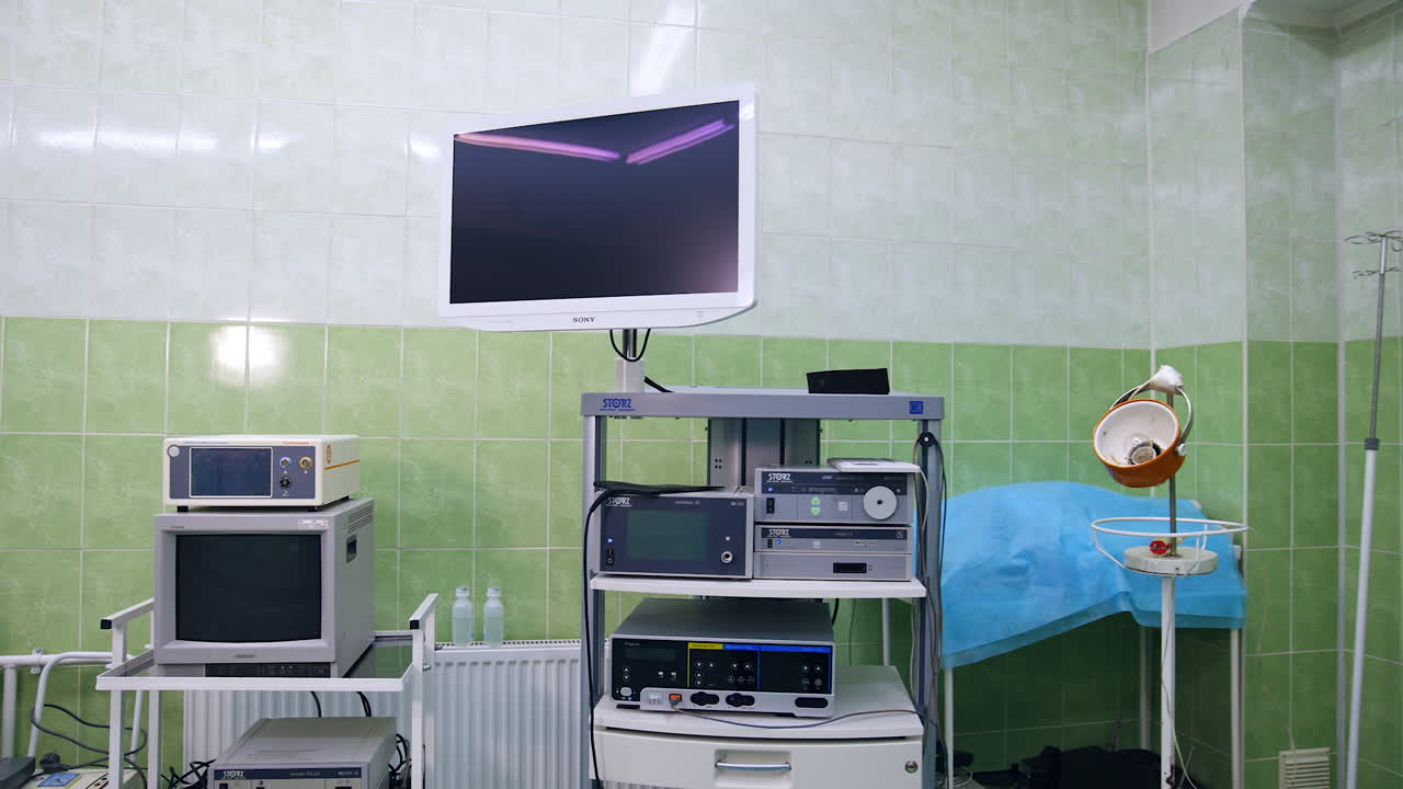 Hospital room with tiled walls and diverse medical equipment. Empty room for dentistry students practice.