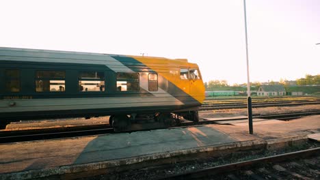 un tren vacío espera para partir con el sol de la mañana ardiendo y brillando a través de los compartimentos, creando una atmósfera cálida y serena
