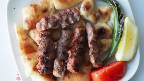 turkish köfte with pide, lemon, and vegetables