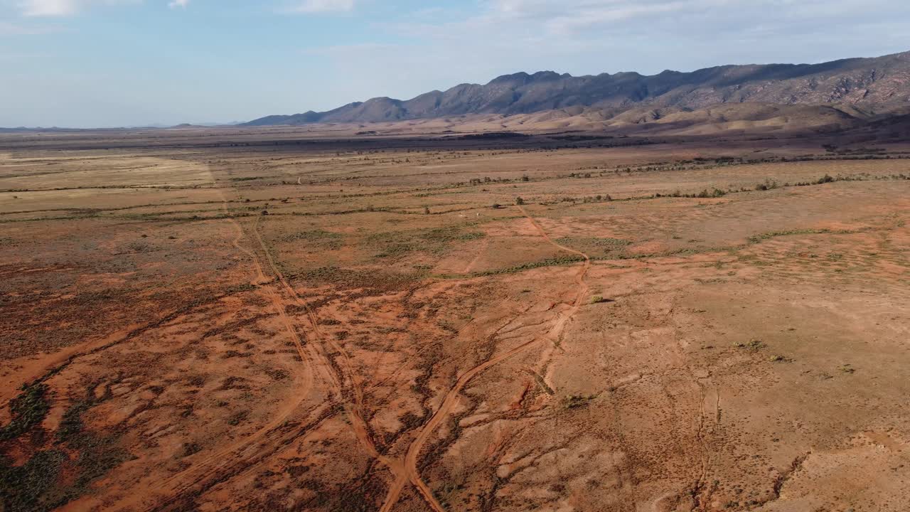 drone filmado sobre tierras estériles afectadas por la sequía con las espectaculares cordilleras de flinders del sur de australia en el fondo