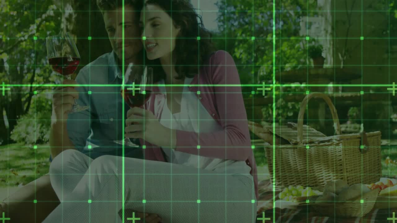 Coppia che arriva al luogo del picnic, stende la coperta, poi versa vino e fa tintinnare i bicchieri per uno spot alimentare.