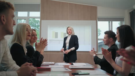 participants of business meeting or conference are applauding and cheering female speaker