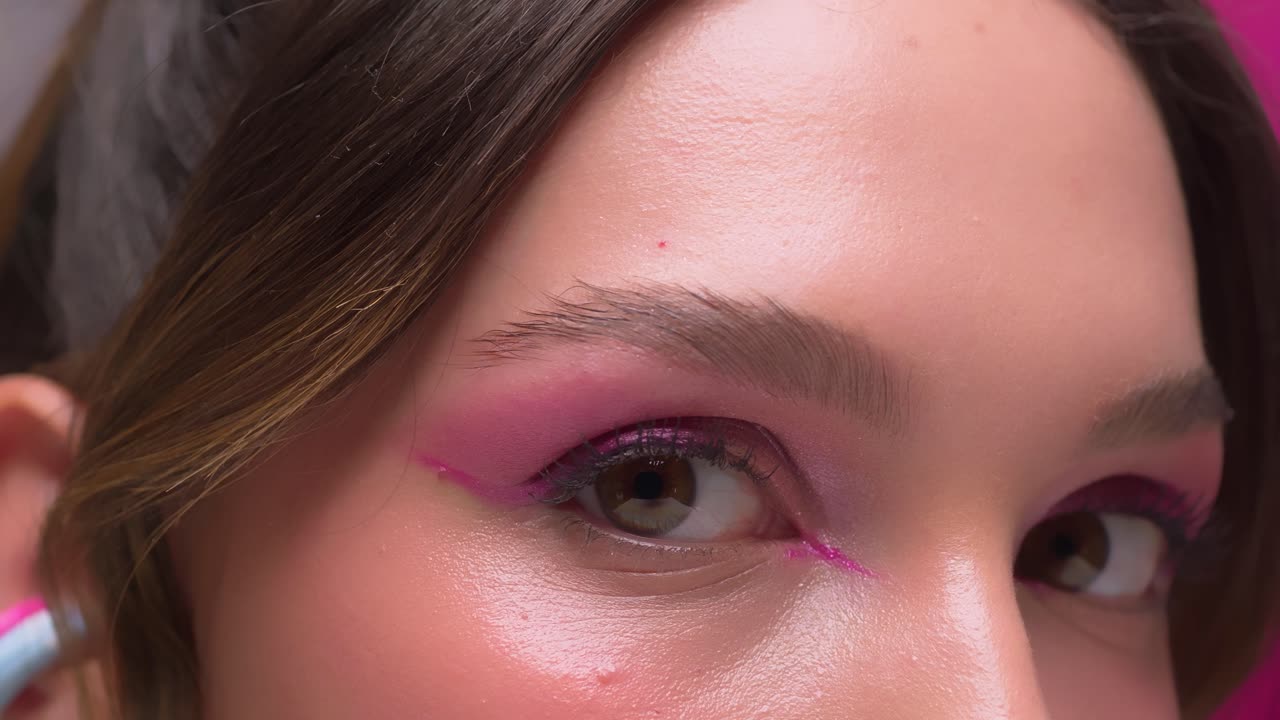 Close-up view of woman’s eyes with pink makeup and defined lashes.