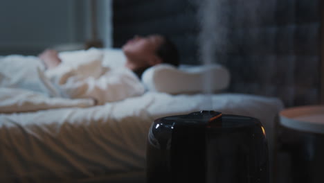 La-Mujer-Está-Durmiendo-Con-El-Humidificador-Encendido,-Ambiente-Hogareño-Acogedor-Y-Relajado