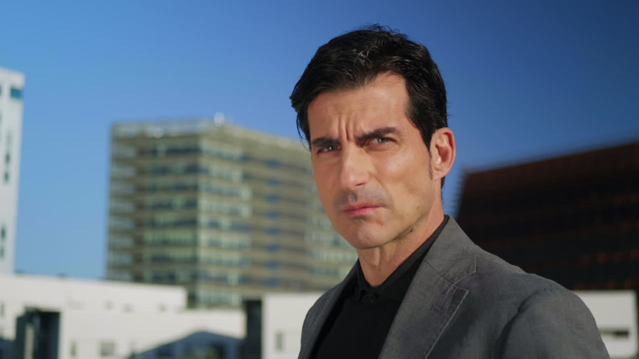 거리에 서 있는 심각한 사업가. 도시 거리에서 카메라에 포즈를 취하는 사람