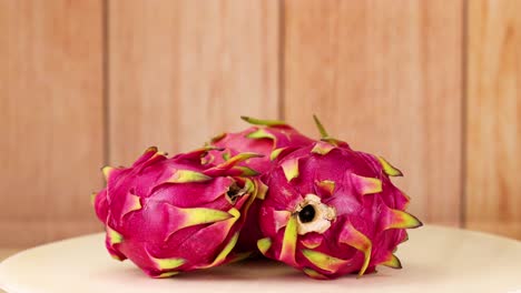 dragon fruits rotating on a wooden surface