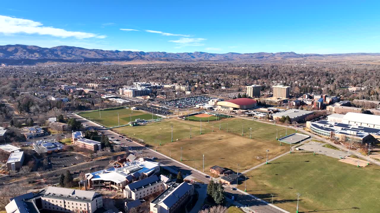 Idrettsbaner på Colorado State Universitys universitetsområde med studentboliger og fjell i bakgrunnen