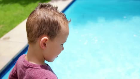Boy-standing-next-to-swimming-pool