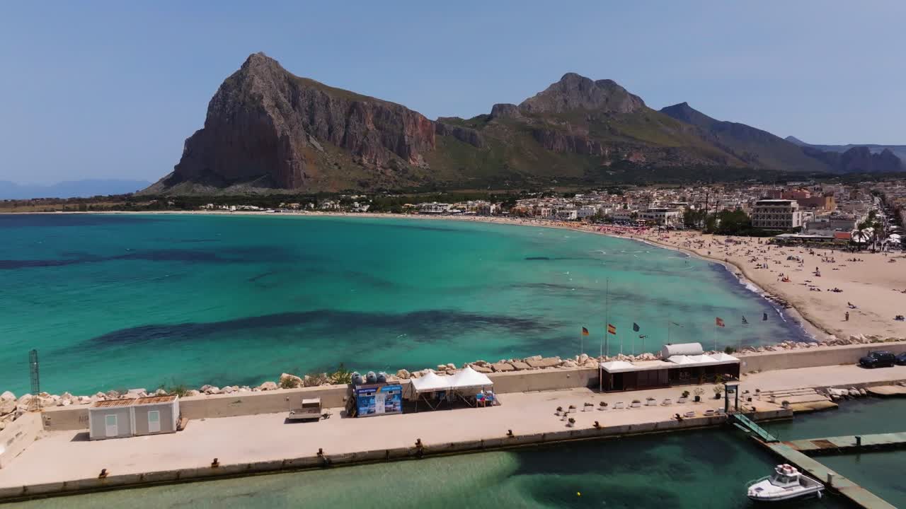 시칠리아의 산 비토 로 카포 해변에서 모나코 산을 배경으로 한 해수욕장을 보여줍니다.
