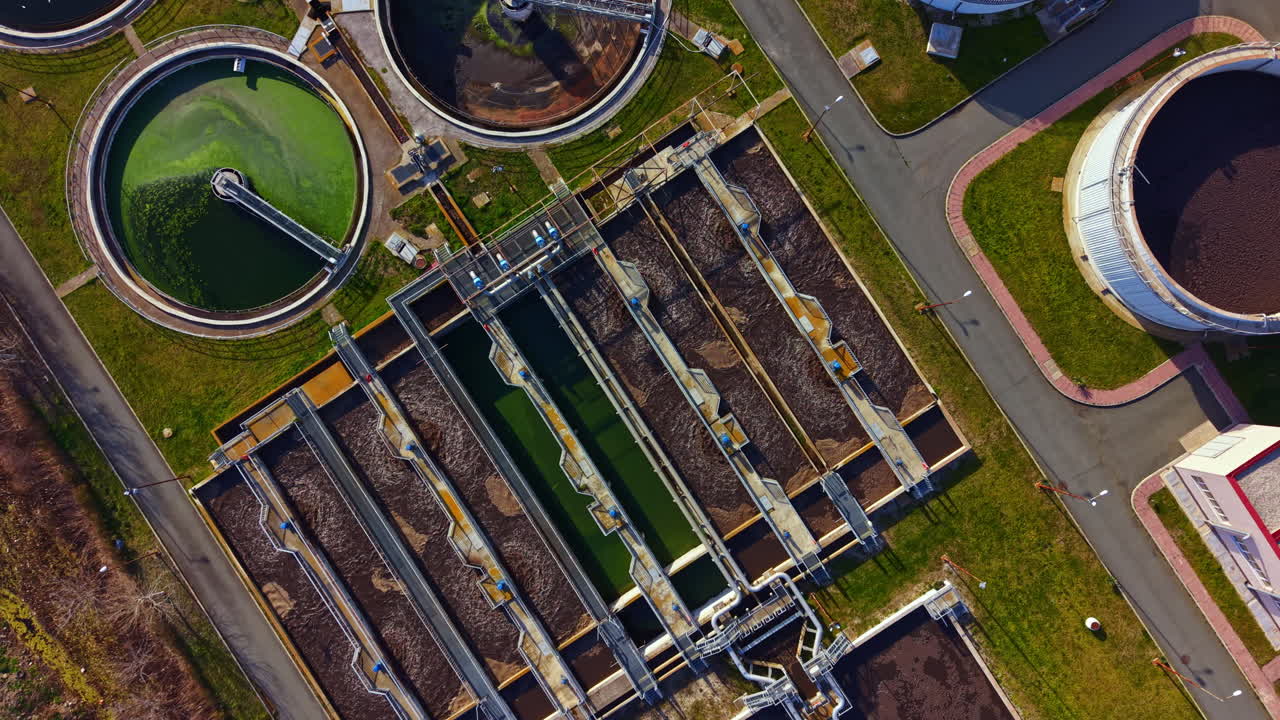 Water treatment facility in operation with multiple large tanks and machinery in daylight