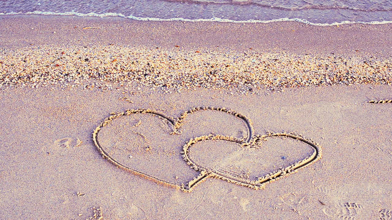 Two hearts on the beach. The loving hearts