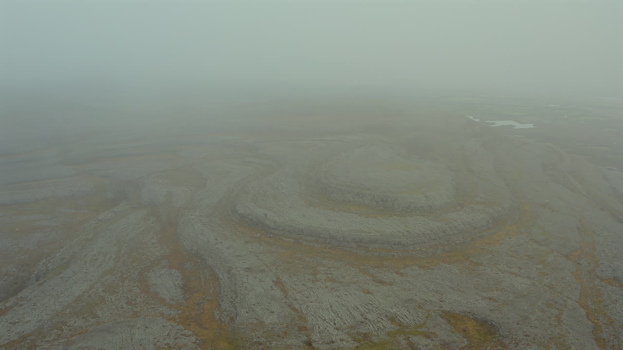 Aerial view of iconic Burren peaks fading into misty skies. Ireland