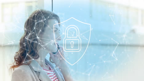 animation of padlock in shield, connected icons over caucasian woman talking on smartphone