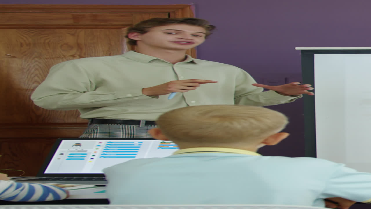 Vertical of Teacher Talking to Group of Schoolchildren at IT Class