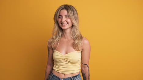 chilling young woman standing against yellow background