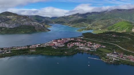 aerial view of a picturesque town on a lake peninsula surrounded by mountains