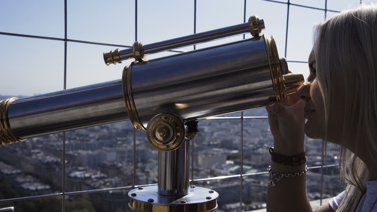 Woman using a telescope at the Eiffel Tower, Paris