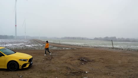 slow-motion shot of a woman walking to her yellow electric car