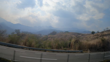 Eine-Ruhige-Fahrt-Entlang-Einer-Kurvenreichen-Bergstraße-Mit-Atemberaubender-Aussicht-Auf-Neblige-Landschaften