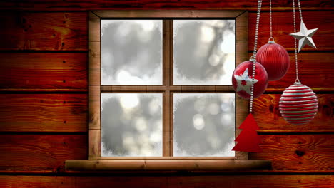 Animation-Von-Weihnachtskugeldekorationen-über-Dem-Fenster-Im-Winterlandschaftshintergrund