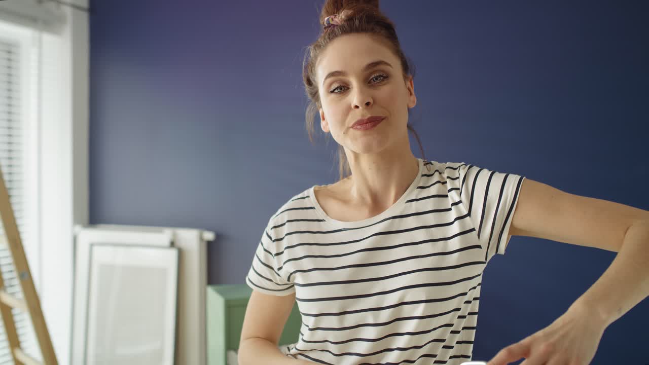 vídeo de retrato en primer plano de una mujer con un rodillo de pintura.
