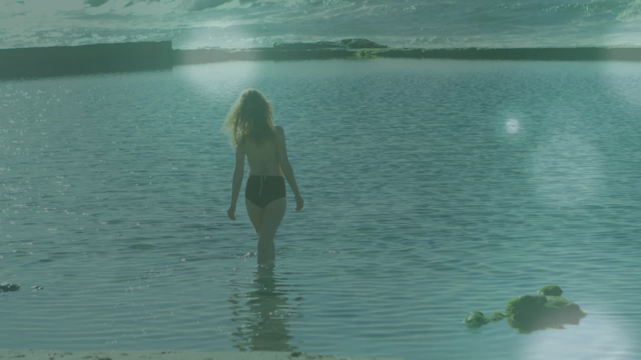 Walking into calm water, person enjoying gentle waves with serene animation