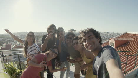 pov of happy friends taking selfie while eating pizza during a rooftop party