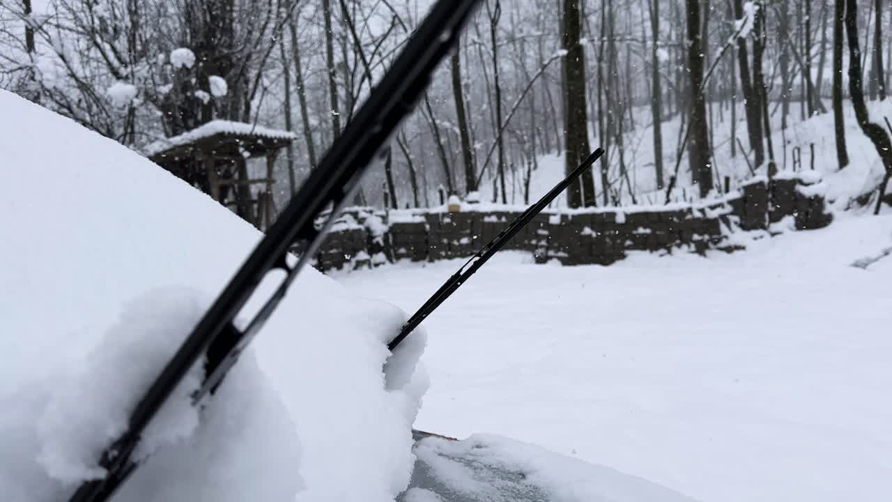 Windshield of car vehicle wiper under snow in forest rural countryside winter landscape Iran nature Hyrcanian scenic view travel frozen cabin mountain white ice highlands transportation frost backyard