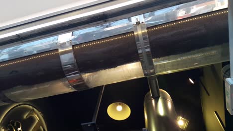 coffee beans spin inside a clear cylindrical coffee roaster inside a coffee shop in thessaloniki greece