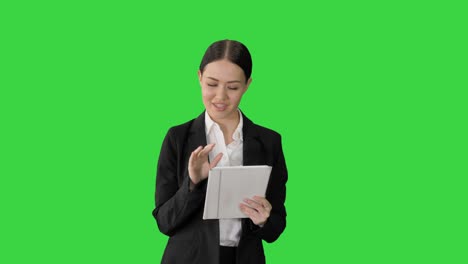 mujer de negocios sonriente usando el teclado de la computadora mientras camina hacia la cámara en una pantalla verde, llave de croma
