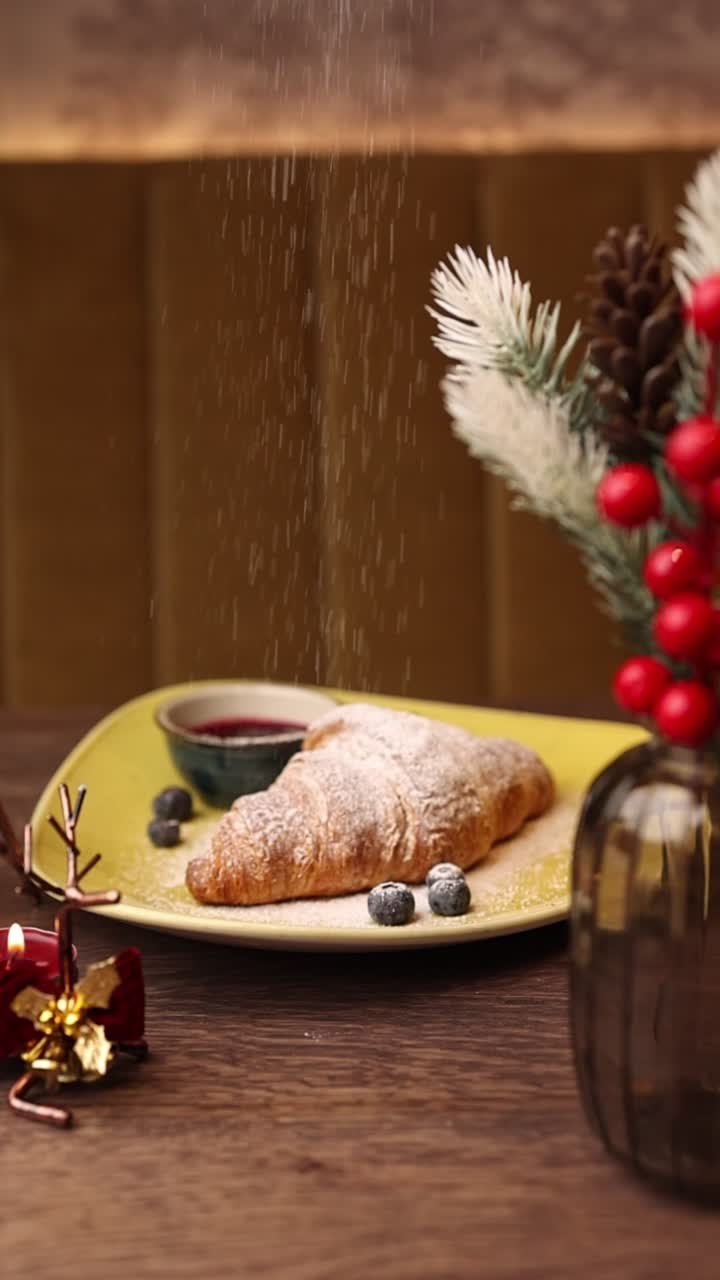 Croissant with powdered sugar, blueberries, and jam for Christmas