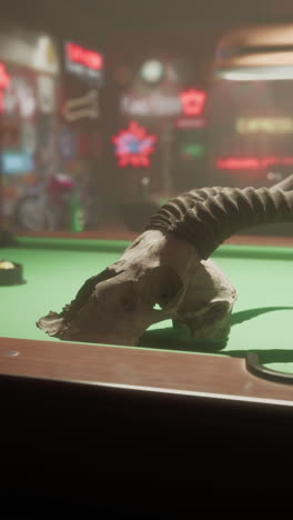 animal skull on pool table in a dimly lit bar