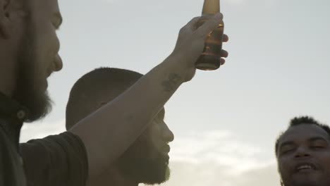 relaxed young men dancing with beer bottles