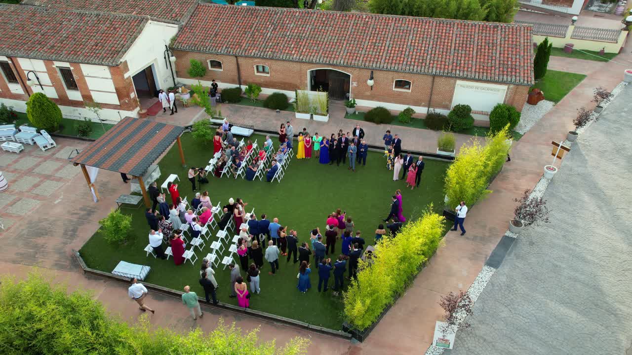 vista aérea estática del novio y la madre que ingresan a la ceremonia de boda en la mansión renacentista