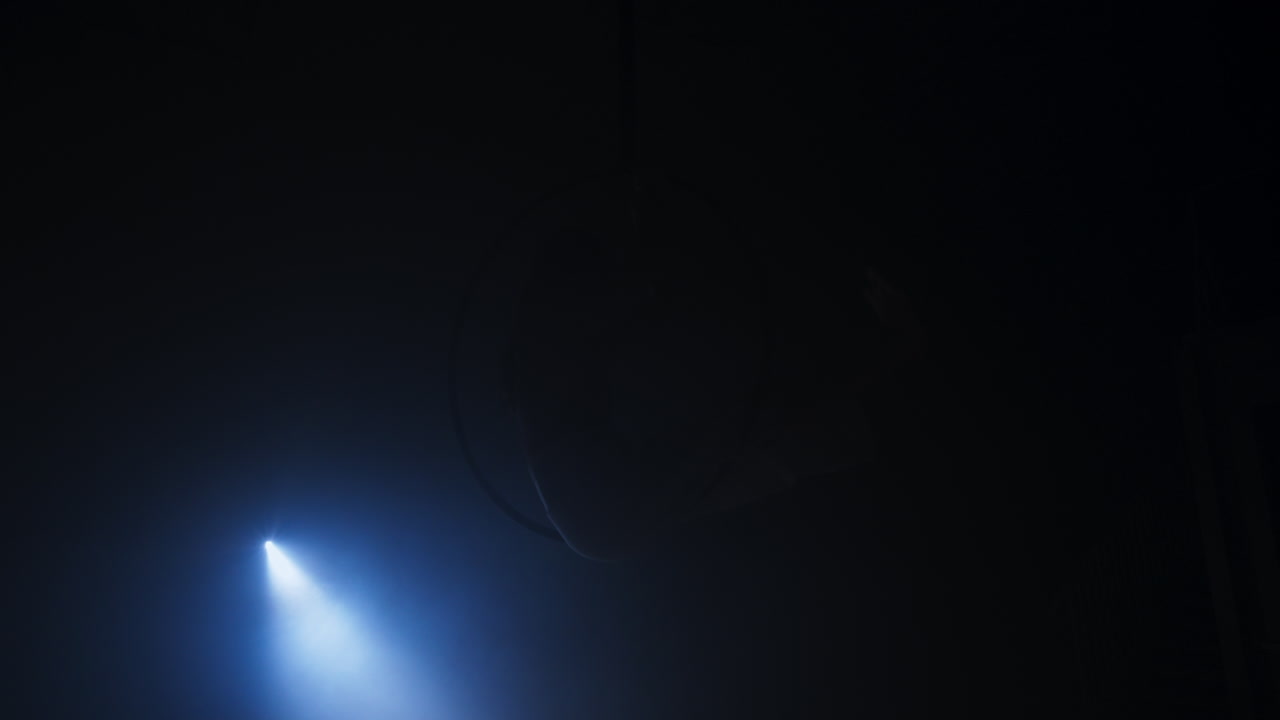 Silhouette of a performer in a dark space lit by a spotlight