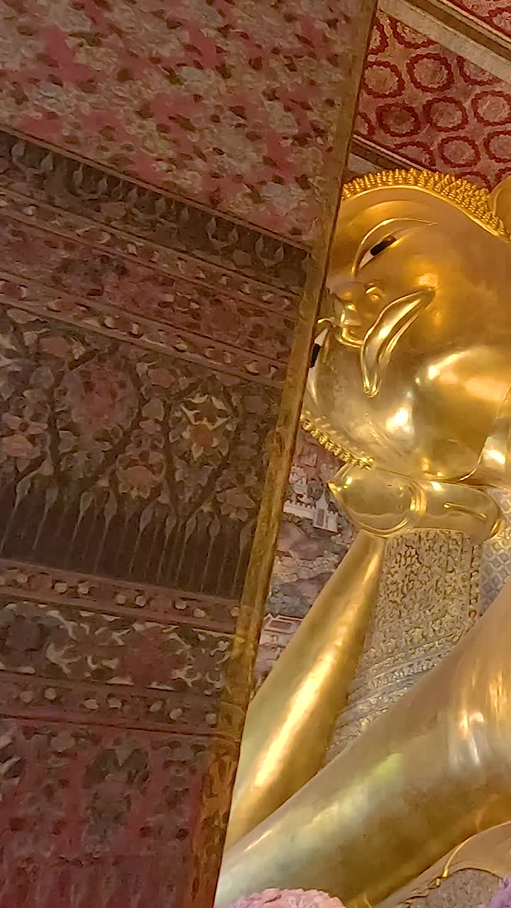 A serene video showcasing the golden Reclining Buddha statue in Bangkok's Wat Pho Temple, highlighting its intricate details and grandeur