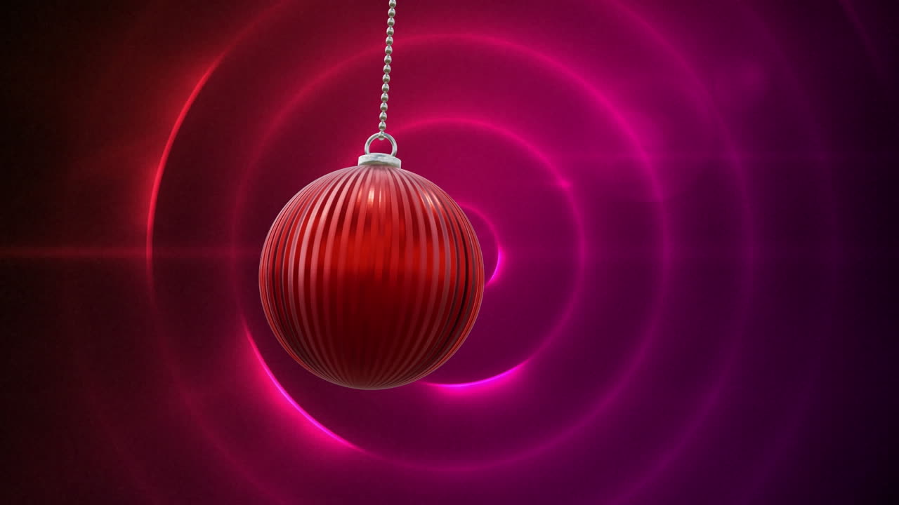 Animation of christmas red bauble and pink and red glowing circles background