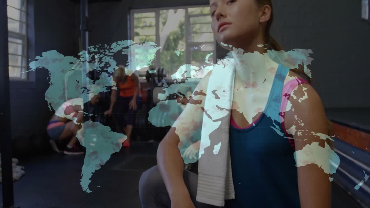 Telecamera che zooma su una donna inginocchiata per il fitness mentre un gruppo prepara i kettlebell, con una mappa pulsante